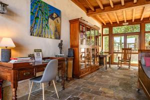 an office with a desk and a table and chairs at Casa da Penela in Mondoñedo