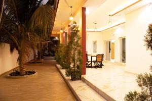 a hallway with potted plants and a table with chairs at Villa Saloum decouvertes in Ndangane