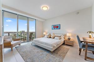una camera da letto con un letto, un tavolo e delle sedie di 2BR 2BA in a Luxury Beach Resort Amrit a Riviera Beach Altre 47 foto