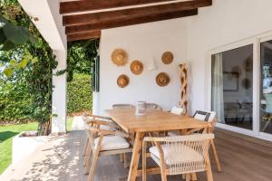 a wooden table and chairs on a patio at Villa Bini Uxuanne in Binibeca