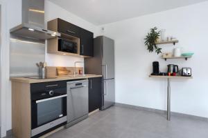 cocina con armarios blancos y negros y lavavajillas en Le Debussy - Wifi - Parking - Centre, en Laval