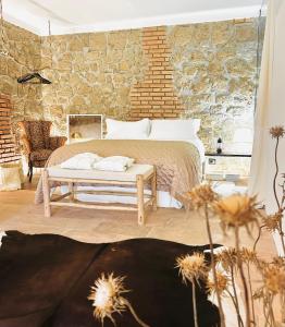 een slaapkamer met een bed en een stenen muur bij Super Galleria in Tuscania