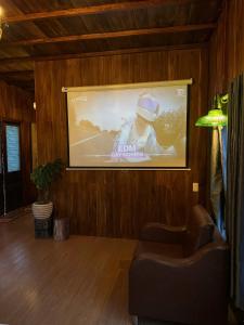 a projection screen in a living room with a tv at Nhà Bên Đồi in Thôn Dương Phẩm