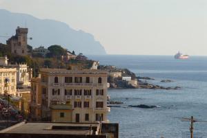 a building on a hill next to a body of water at Hotel Tirreno in Genoa