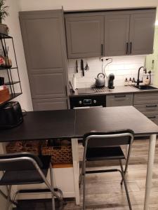 a kitchen with a black table and two chairs at PaprikanTiny House in Uppsala +13 photos