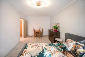 a bedroom with a bed and a table in it at Urban escape Kaunas - One bedroom apartment Krėvės 16 in Kaunas +2 photos