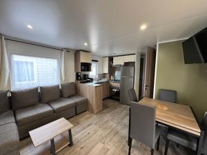 una sala de estar con un sofá y una mesa en Mobil-home Bora camping les Embruns, en Lège-Cap-Ferret