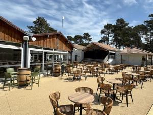 un grupo de mesas y sillas en un patio en Mobil-home Bora camping les Embruns, en Lège-Cap-Ferret