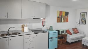 a kitchen with white cabinets and a blue refrigerator at Casa do Apeadeiro in Vila Pouca de Aguiar