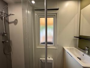 baño con ducha, lavabo y ventana en Mobil-home Bora camping les Embruns, en Lège-Cap-Ferret 14 fotos más