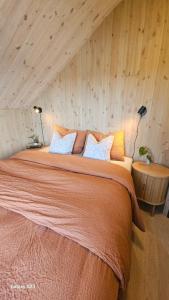 a large bed in a room with wooden walls at Sjåen på Balsnes Gård in Hitra