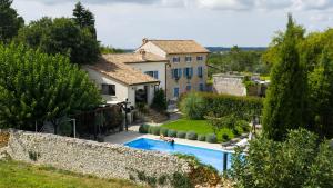 a villa with a swimming pool in front of a house at Scuola Roveria in Juršići