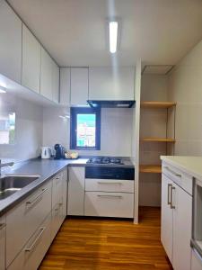 a kitchen with white cabinets and a stove top oven at 湯音の櫻 in Kusatsu +15 photos