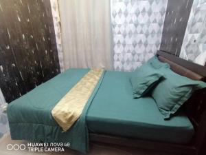 un letto con lenzuola e cuscini blu in una stanza di Homestay Putrajaya Milmot a Gua Sai