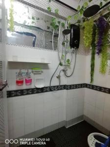 e bagno piastrellato con doccia e lavandino. di Homestay Putrajaya Milmot a Gua Sai Altre 15 foto