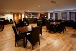 uma sala de jantar com mesas e cadeiras e um bar em Borve House Hotel em Borve