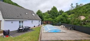 ein Haus mit einem Pool auf einer Holzterrasse in der Unterkunft Modernité et Nature avec Piscine in Sainte-Marie-aux-Mines