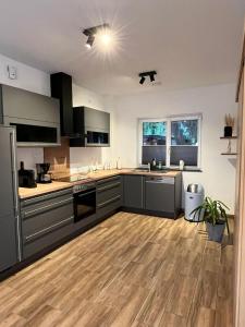 ヒルシャイトにあるFerienhaus Fei schö Hirschaidの木製の床のキッチン(グレーのキャビネット付)