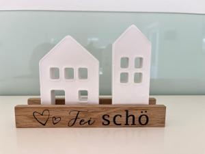 ヒルシャイトにあるFerienhaus Fei schö Hirschaidの2軒の白い家と「ヨー・ティー・サロン」と書かれた木の看板 +20枚の写真