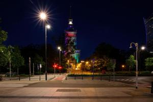 a view of the eiffel tower lit up at night at Spacious and Bright Apartment with Parking in the City Center by Noclegi Renters in Warsaw