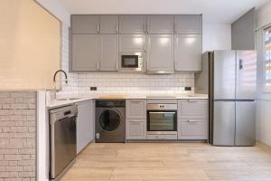 a kitchen with stainless steel appliances and white cabinets at San Mamés Apartment in Bilbao +10 photos