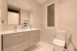 a white bathroom with a toilet and a sink at San Mamés Apartment in Bilbao