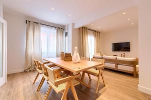 a dining room with a table and chairs and a couch at San Mamés Apartment in Bilbao