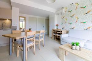 a kitchen and living room with a table and a couch at SELECT'soHOME - Vacances Tout Confort - 3 Pièces avec Piscine, Parking et Plage à Pied - POS36 in Bormes-les-Mimosas