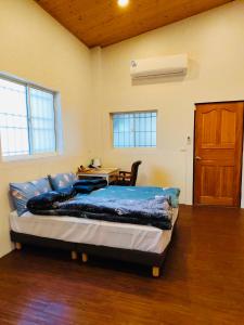 Un dormitorio con una cama y una mesa y una puerta. en 寵物友善 漫步森活 九樺落羽松民宿, en Guoxing