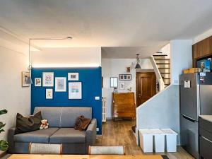 Una sala de estar con un sofá y una pared azul. en Terrazza sul tetto, en Cannobio