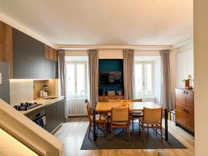 Una cocina con mesa de comedor y sillas. en Terrazza sul tetto, en Cannobio