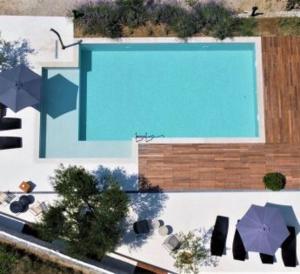 an overhead view of a swimming pool with umbrellas at The Bellevue Lodge in Lopar