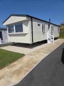 Una caravana blanca está estacionada en una entrada en 61, Stowford Gardens, en Combe Martin