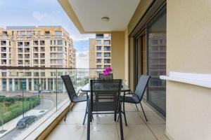 DbayehにあるViva - Elegant 3-BR Apt & Balcony at Waterfront Dbayehのバルコニーにテーブルと椅子が置かれたダイニングルーム