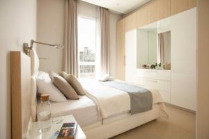 Ar RumaylにあるComfy - 1BR Apt W Pool & Gym in Gemmayzeのベッドと窓のある白い寝室