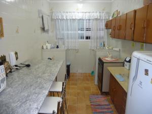 a kitchen with a counter top and a refrigerator at Apartamento 1 Quarto Edificio Tokio in Praia Grande
