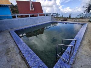 a pool of water in front of a red building at BBASAN FARMs in Darjeeling