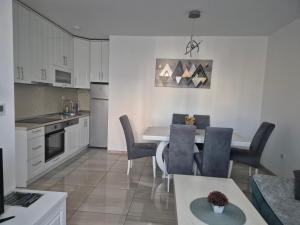 a kitchen and dining room with a table and chairs at Apartman SIMS in Bijeljina