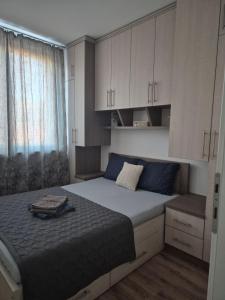 a bedroom with a large bed and white cabinets at Apartman SIMS in Bijeljina +7 photos