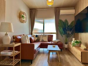 una sala de estar con un sofá y una mesa en キングベッドコンビニ465TVNetflixモカポット, en Kishiwada