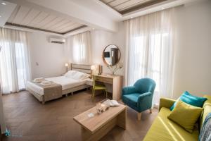 ein Schlafzimmer mit einem Bett, einem Sofa und einem Tisch in der Unterkunft Polis of Naxos Boutique Hotel in Naxos Chora