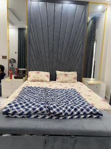 une chambre avec un grand lit avec une grande tête de lit dans l'établissement luxury villa in murree for families and couples, à Murree