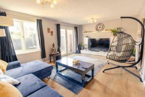 a living room with a blue couch and a table at House - Sleeps 8 - Pet friendly - Garden - Parking in Andover