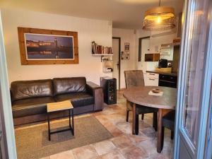 un soggiorno con un divano e un tavolo di Idéal famille et amis, 2 logements en 1 maison, patio privé, parking, quartier des peintres et plages à pieds a Collioure