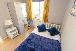 a bedroom with a bed with two blue pillows on it at 3 Bedrooms - Sleeps 8 - Wifi - 3 Car Parking in Andover