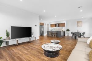 a living room with a large flat screen tv at Bright & Roomy 5BR Clyde North Home in Clyde North