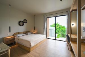 a bedroom with a bed and a large sliding glass door at Ocean Dream Uluwatu by Hello Summer in Uluwatu +57 photos