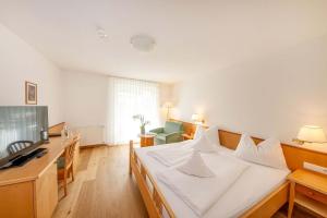 een slaapkamer met een bed, een bureau en een televisie bij Hotel Julius Payer in Solda +32 foto's