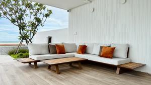 a white couch with pillows and a wooden coffee table at Topseavilla Poolmoon 2 bedroom in Ban Bo Yai
