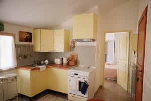 a small kitchen with yellow cabinets and a bed at LaPetite Maison Abigail, Peaceful home in Avignon in Avignon